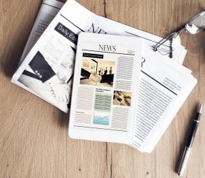 Newspaper With Tablet On Wooden Table